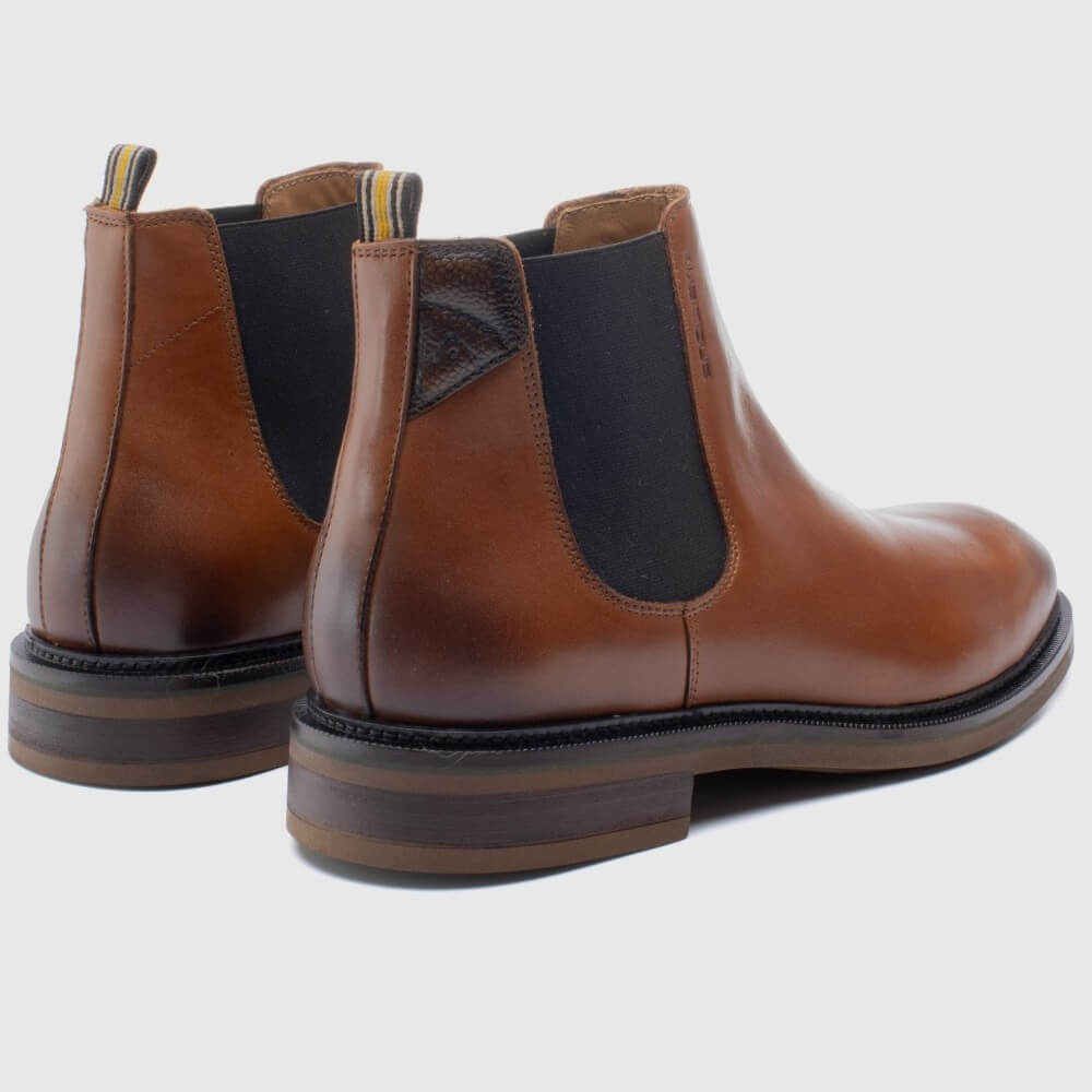 Pair of brown leather boots with black accents on a light gray background