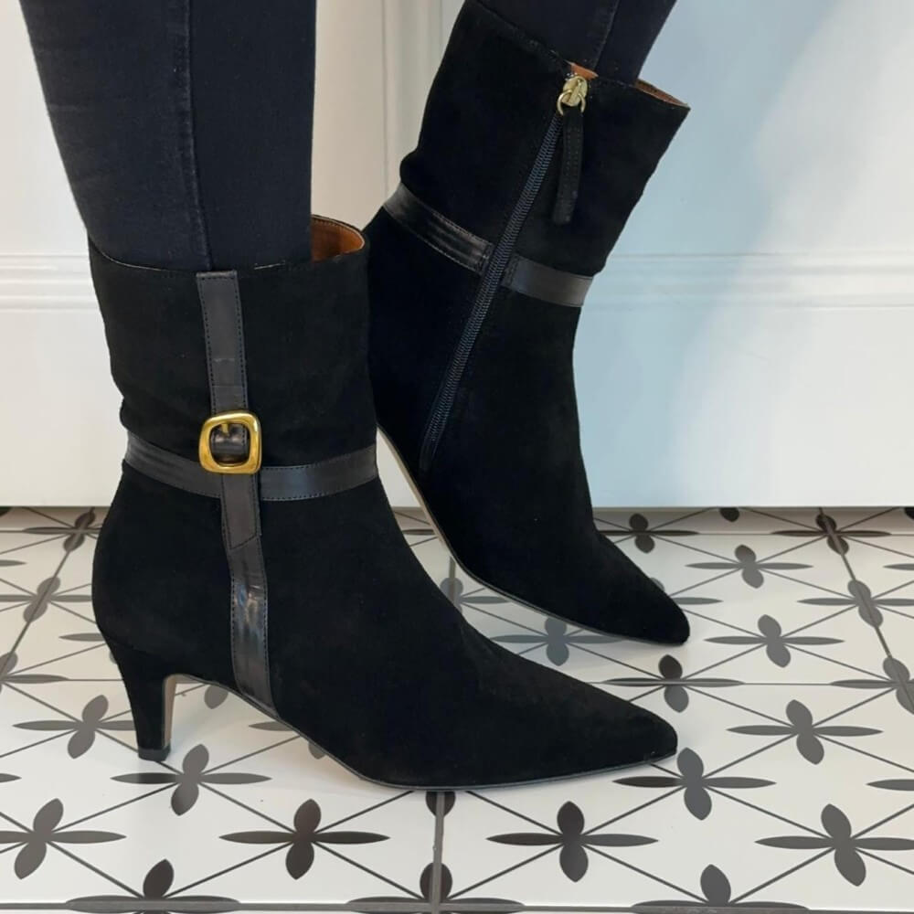 Black suede boots with buckles on a patterned floor Ángel Alarcón Florine 25602 Suede Ankle Boot-BLACK