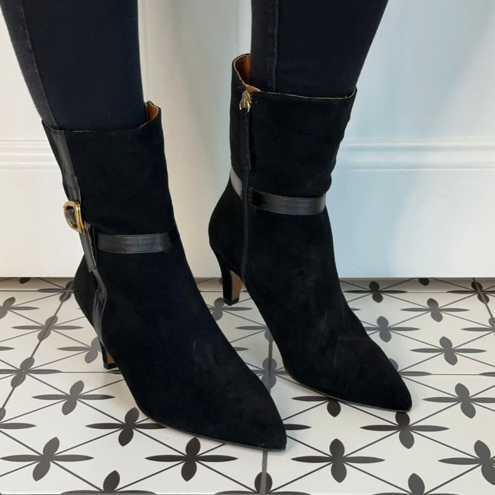 Black suede boots with buckles on a patterned floor Ángel Alarcón Florine 25602 Suede Ankle Boot-BLACK