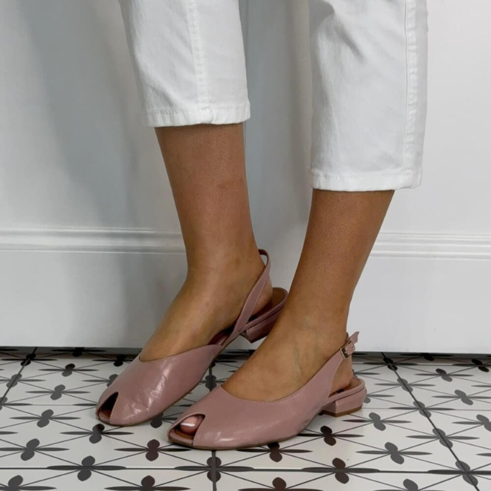 Angel Alarcon Blush Pink slingback peep toe shoes worn with white pants on a patterned floor.
