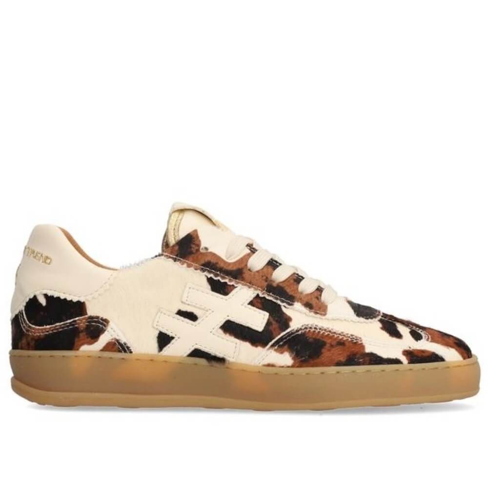 Sneaker with cow print pattern on a white background