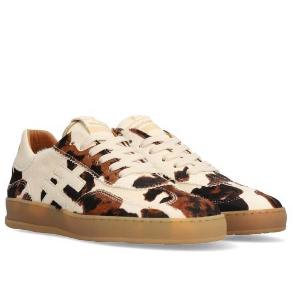 Sneaker with cow print pattern on a white background