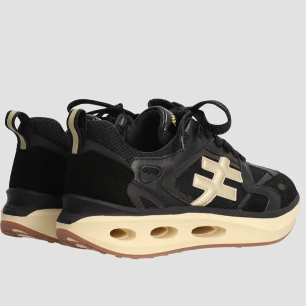 Black and beige sneaker with unique sole design on a light gray background