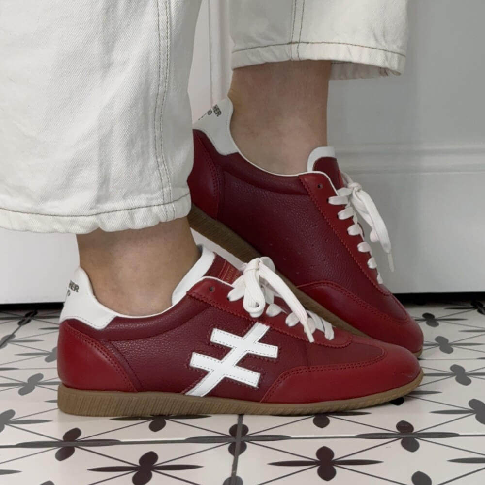 Another Trend Red and White Leather sneakers worn with a white jeans on a patterned floor