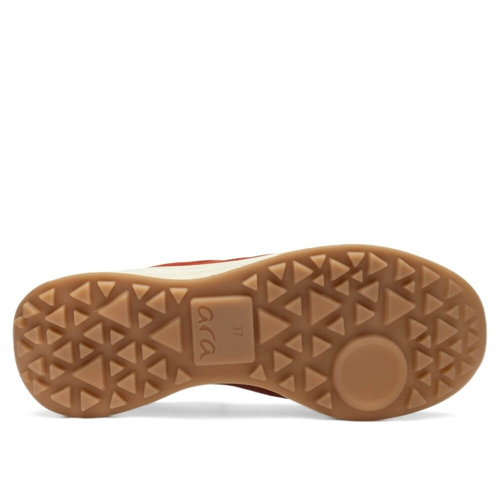 The bottom sole of a shoe, showing a textured brown rubber tread with a circular heel pad and embossed brand lettering, photographed against a white background.