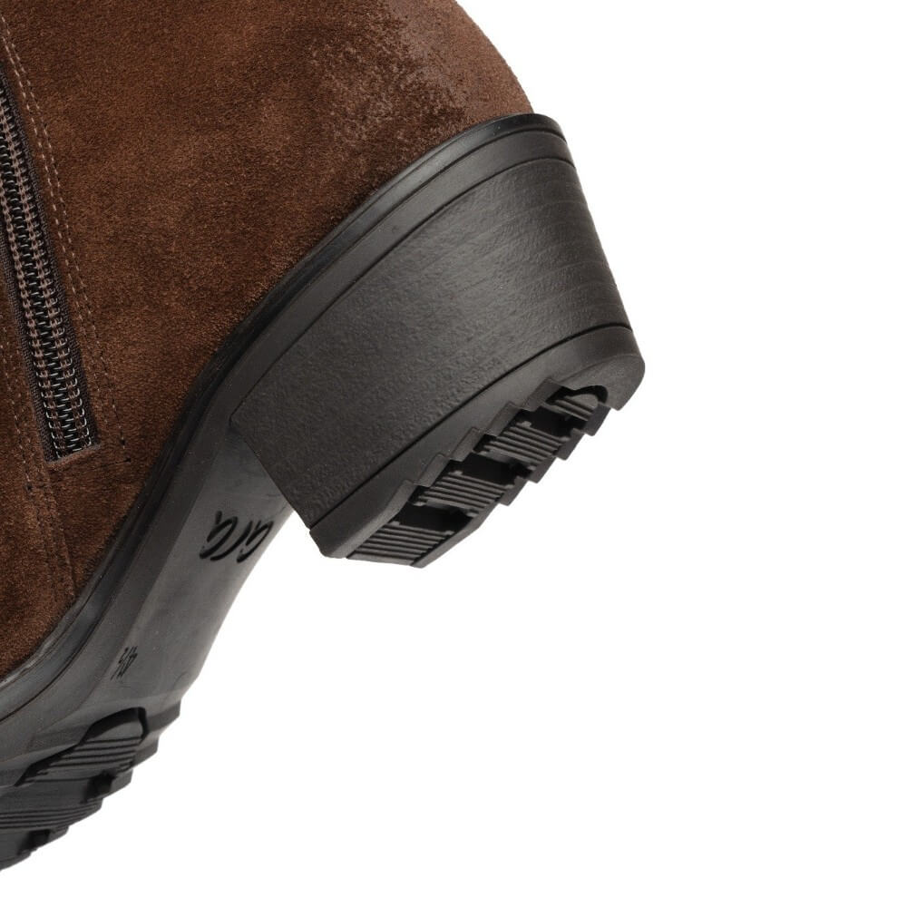 Close-up of the heel and side profile of a brown suede ankle boot with a black lug sole and block heel, on a white background.