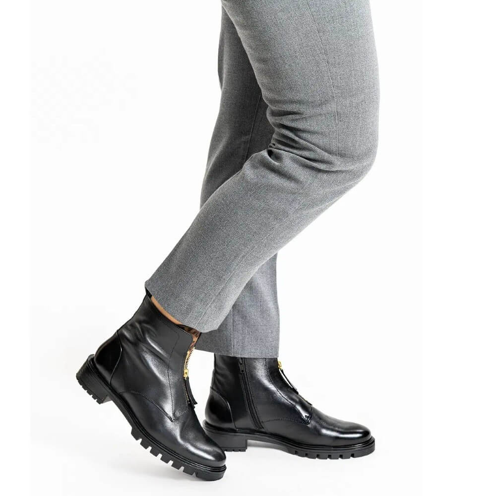 ara Black leather ankle boots with side zippers and gold-tone hardware, shown on a model wearing grey trousers against a white background.