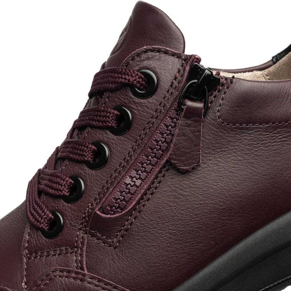 Close-up of a dark burgundy leather lace-up shoe with a side zipper, black metal eyelets, and matching burgundy laces on a white background.