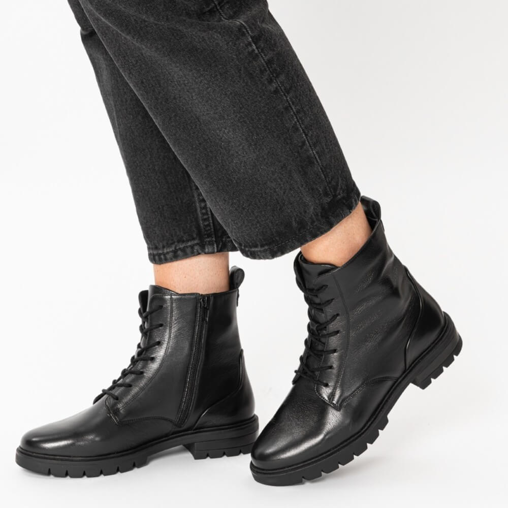 Black leather boots worn with black jeans on a white background Ara Cambridge Leather Laced Ankle Boots 12-11260 Black