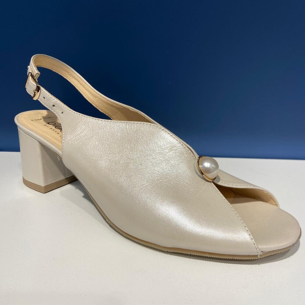 Bioeco Beige sandal with a block heel on a white surface with a blue background