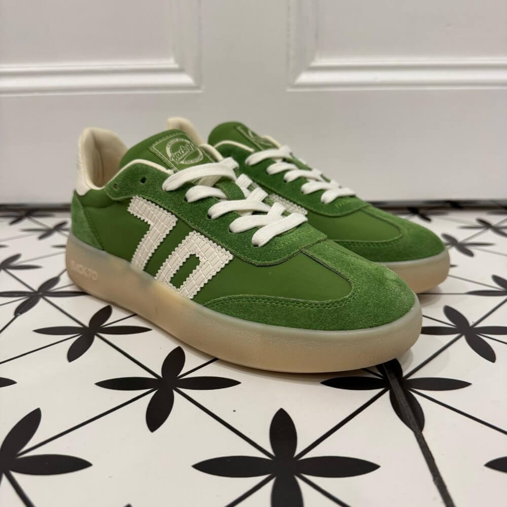 Back 70 Brooklyn Green sneakers with white laces on a black and white patterned floor.