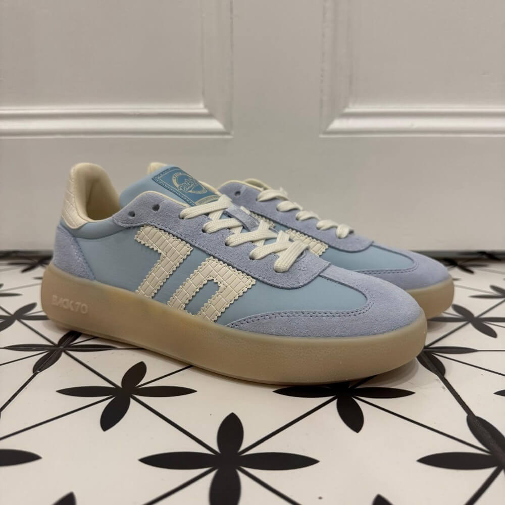 Back 70 Brooklyn light blue sneakers with beige soles on a black and white patterned floor.