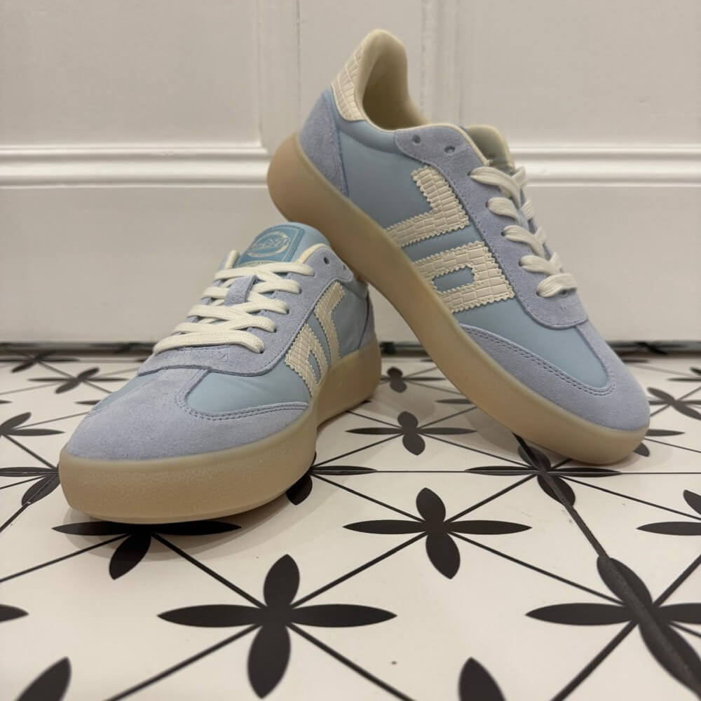 Back 70 Brooklyn light blue sneakers with beige soles on a black and white patterned floor.