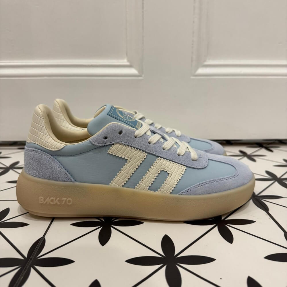Back 70 Brooklyn light blue sneakers with beige soles on a black and white patterned floor.
