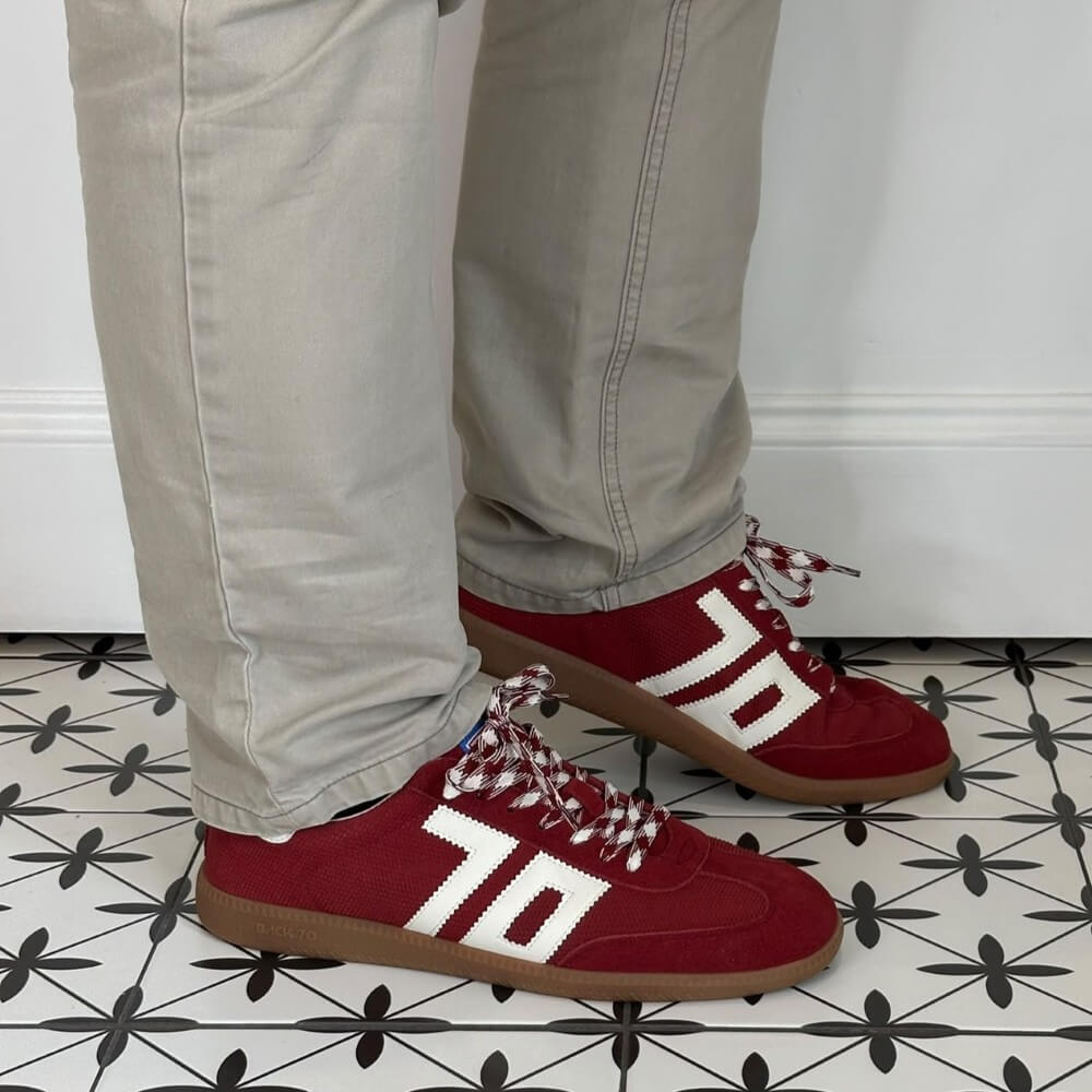 Back 70 Red sneakers with white accents worn on a patterned floor.