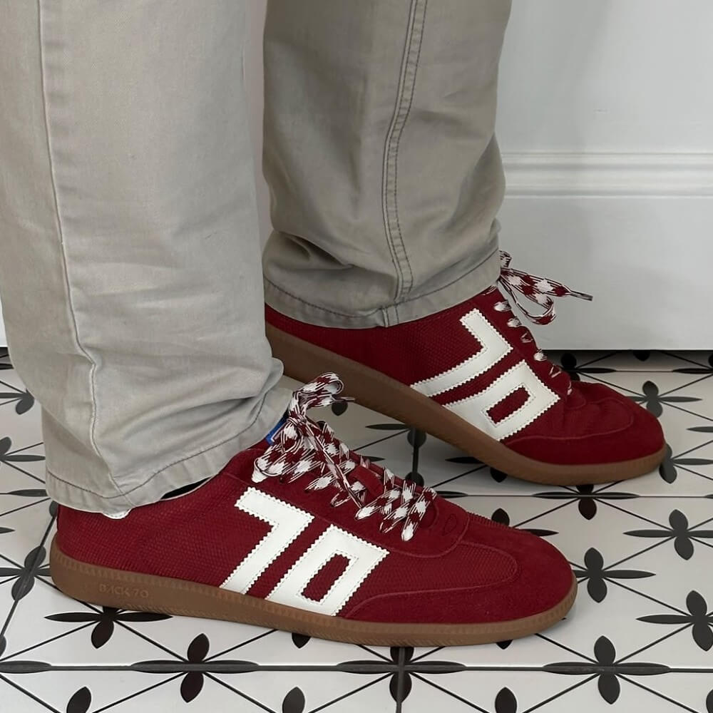Back 70 Red sneakers with white accents worn on a patterned floor.