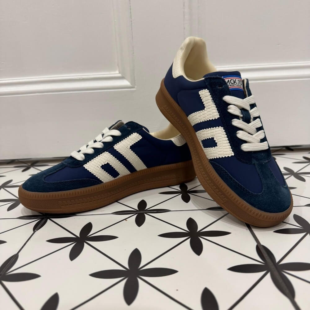 Back 70 Navy Blue and white sneakers with brown Gum soles on a patterned floor.