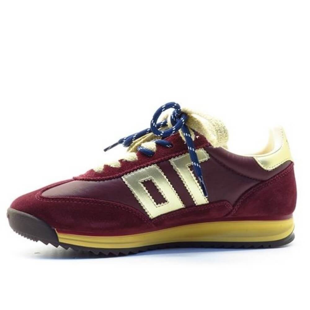 A low-top sneaker in burgundy suede and leather, featuring a prominent cream-colored 'Back 70' logo on the side, cream laces, a cream heel tab, and a yellow midsole, with blue laces threaded through the eyelets.