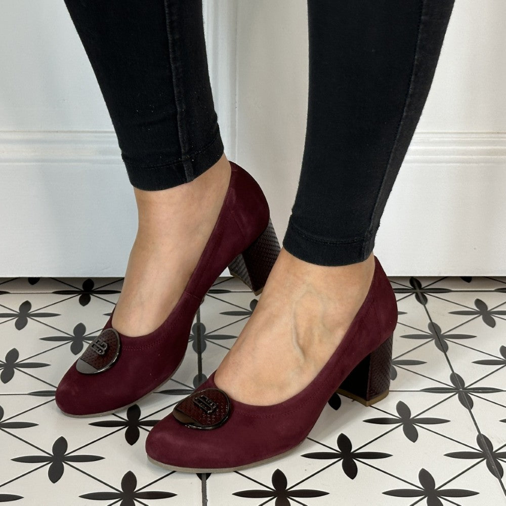 Wine high-heeled shoes worn with black pants on a patterned floor. Bioeco 6844 Block Heel Burgundy Suede