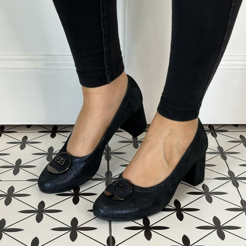 Navy Shimmer high-heeled shoes worn with black pants on a patterned floor. Bioeco 6844 Block Heel Navy Shimmer Suede court shoes