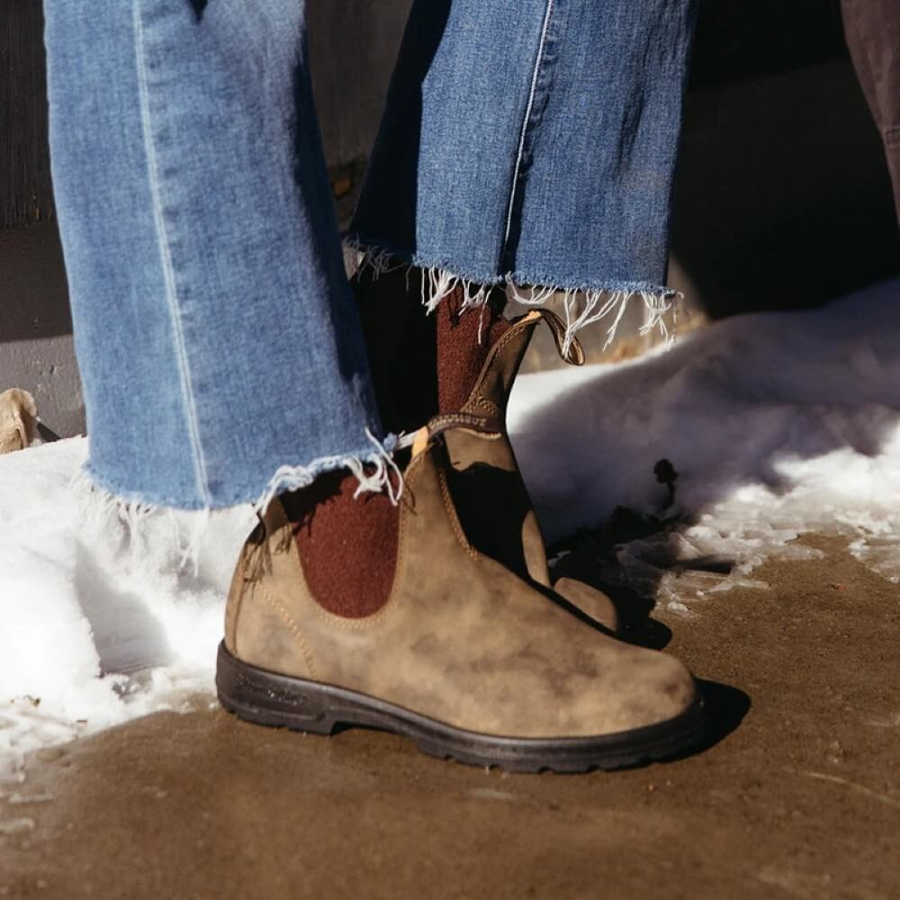 Brown boots with a patch on a snowy ground