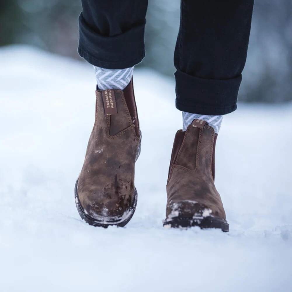 Brown boots in the snow with a blurred background