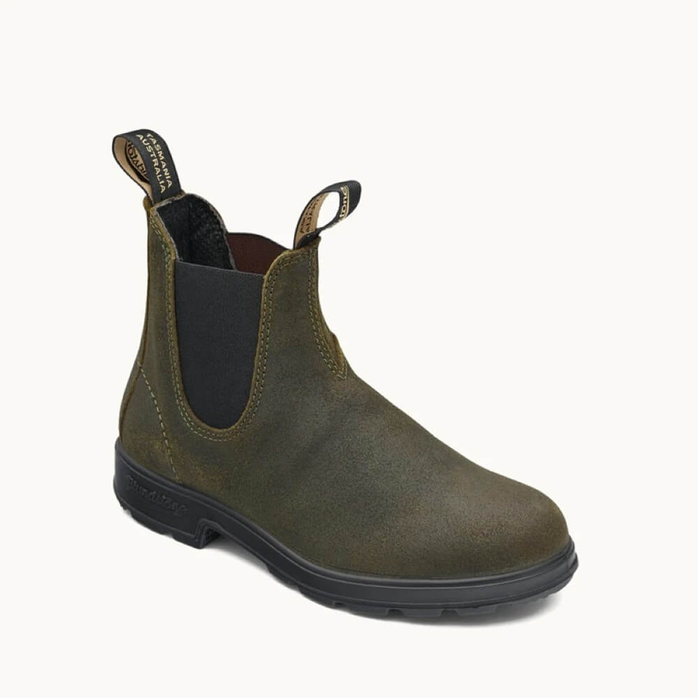 Green Chelsea boot with black sole on a white background
