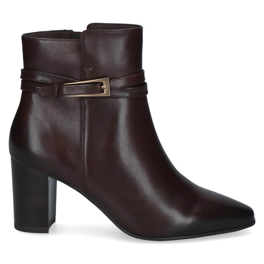 A Caprice dark brown leather ankle boot with a block heel, pointed toe, and a decorative strap with a gold-tone buckle detail around the ankle.