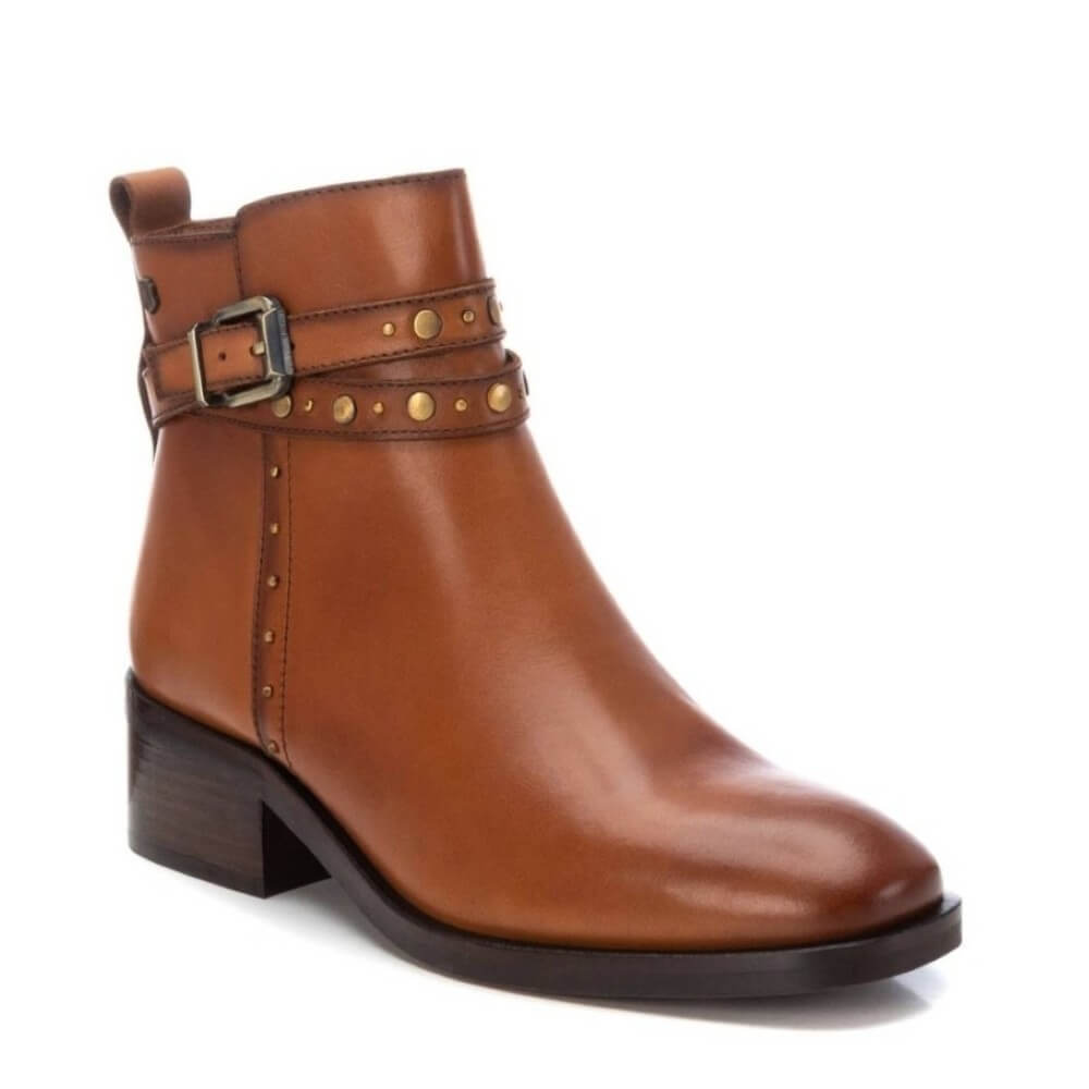 Brown leather boot with strap and buckle on a white background