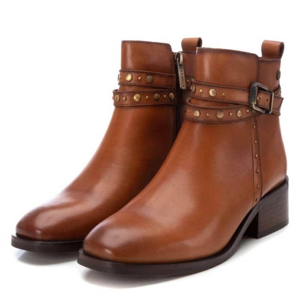 Pair of brown leather boots with studded details on a white background