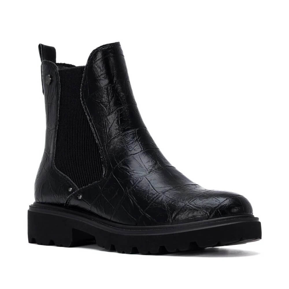 A Carmela black Chelsea-style ankle boot with a textured embossed pattern on the upper, black elastic side gore, and a chunky lug sole, shown on a plain white background.