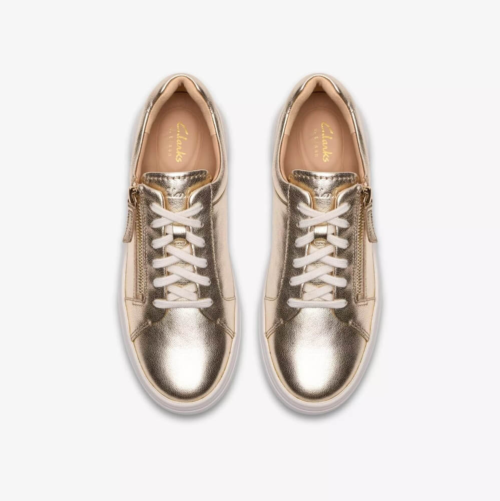 Clarks Gold sneakers with white soles on a white background