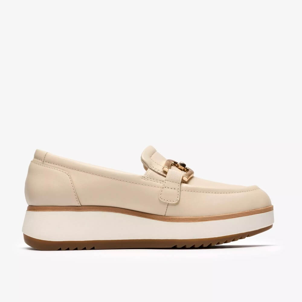 Clarks Beige loafer shoe with a gold buckle on a white background