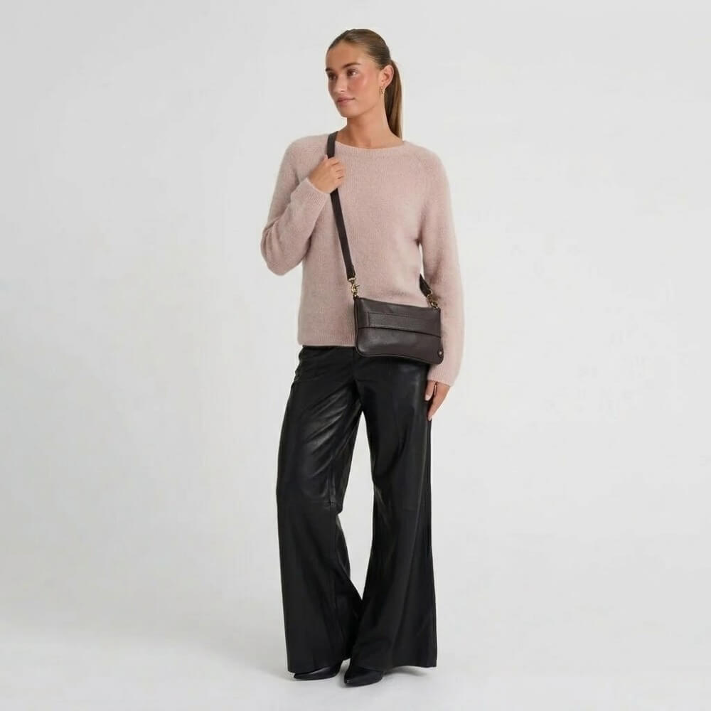 Person wearing a Depeche Brown Leather Clutch bag with a shoulder strap