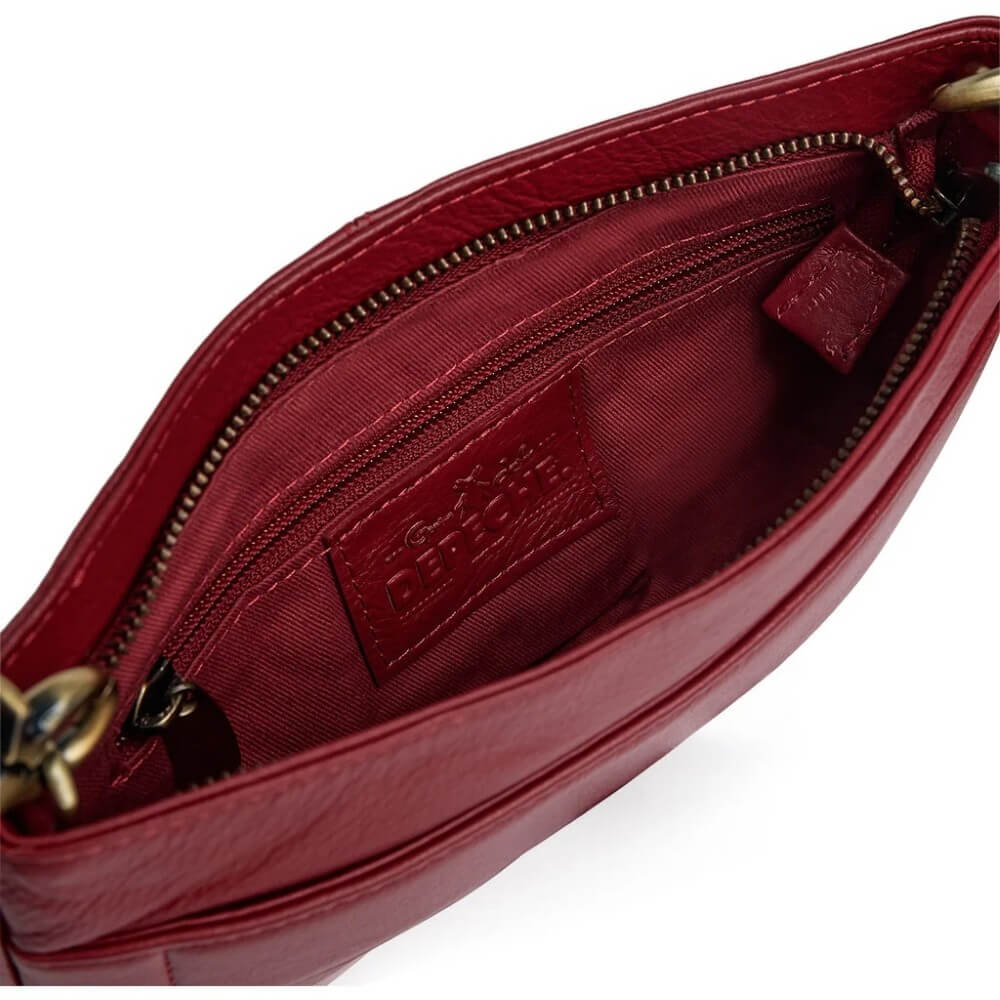 Close-up of the interior of a burgundy leather handbag, showing a zippered compartment with a matching leather brand patch and gold-tone zipper hardware.