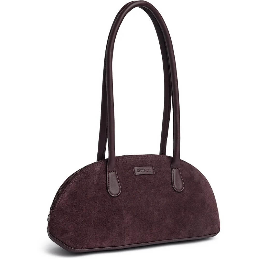 A Depeche dark plum purple suede shoulder bag with double top handles and a small leather brand plaque on the front, shown against a plain white background.