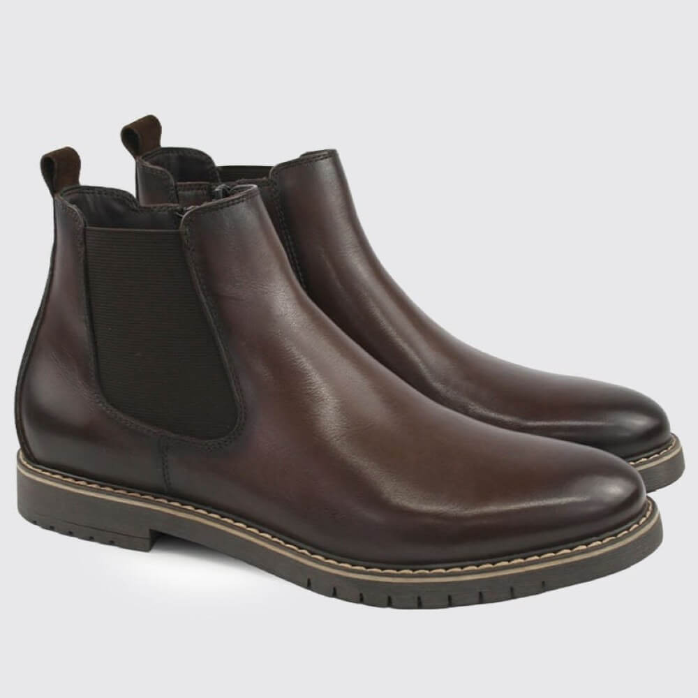A pair of Dubarry dark brown leather Chelsea boots with black elastic side panels, shown on a light grey background.