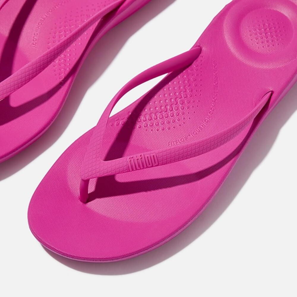 Pair of pink flip-flops on a white background