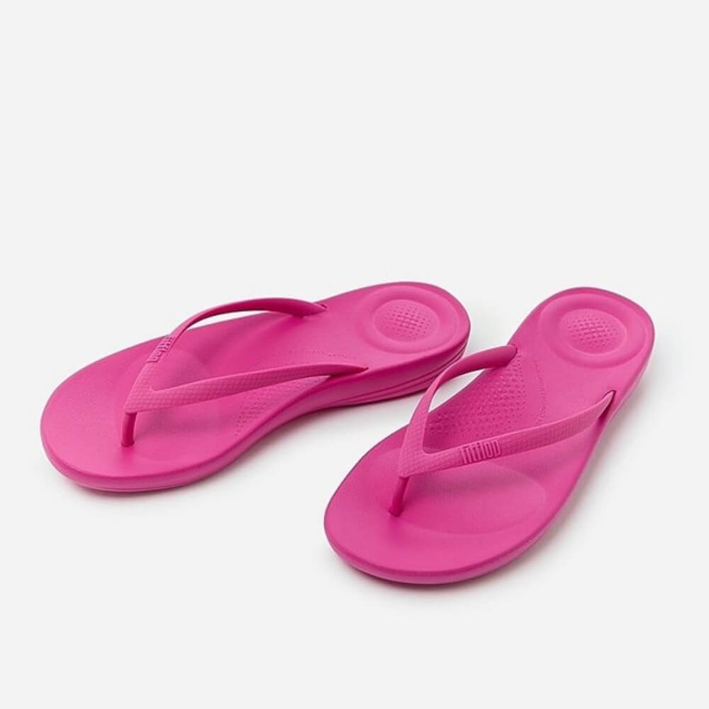 Pair of pink flip-flops on a white background