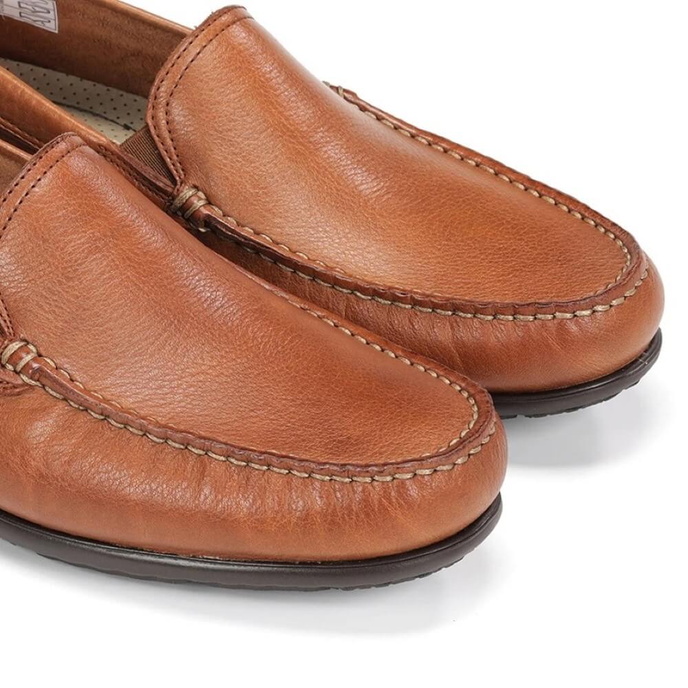 Pair of Fluchos brown leather loafers on a white background