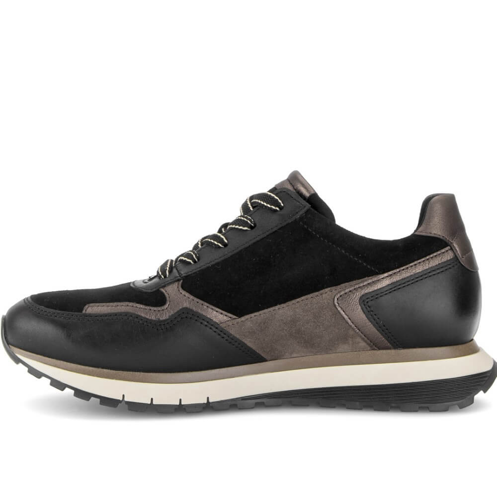 A low-top sneaker shown from the side profile on a white background. The shoe features a black suede and leather upper with taupe-brown synthetic overlays, black laces, and a thick white midsole with a black outsole.