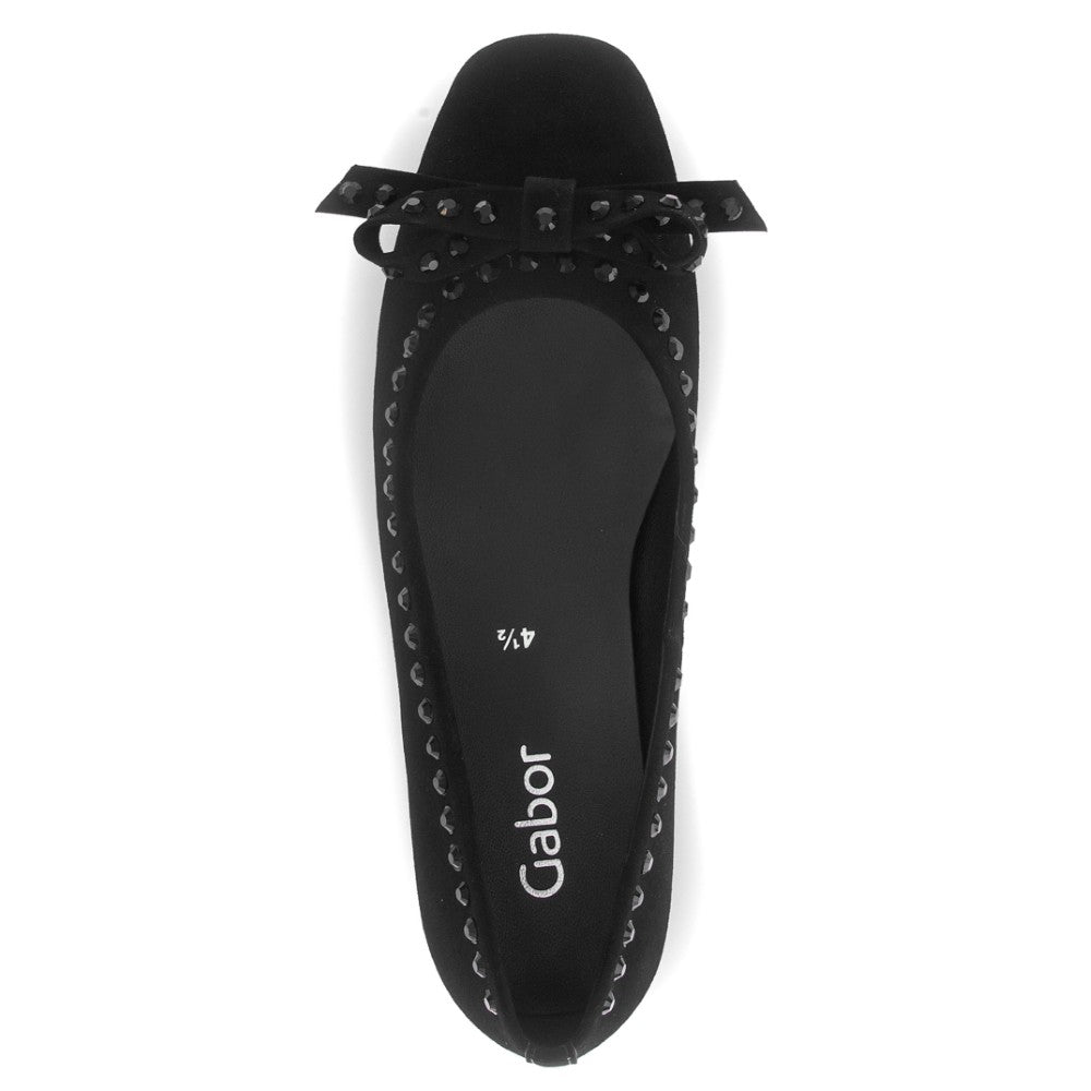 Black flat shoe with decorative bow on a white background