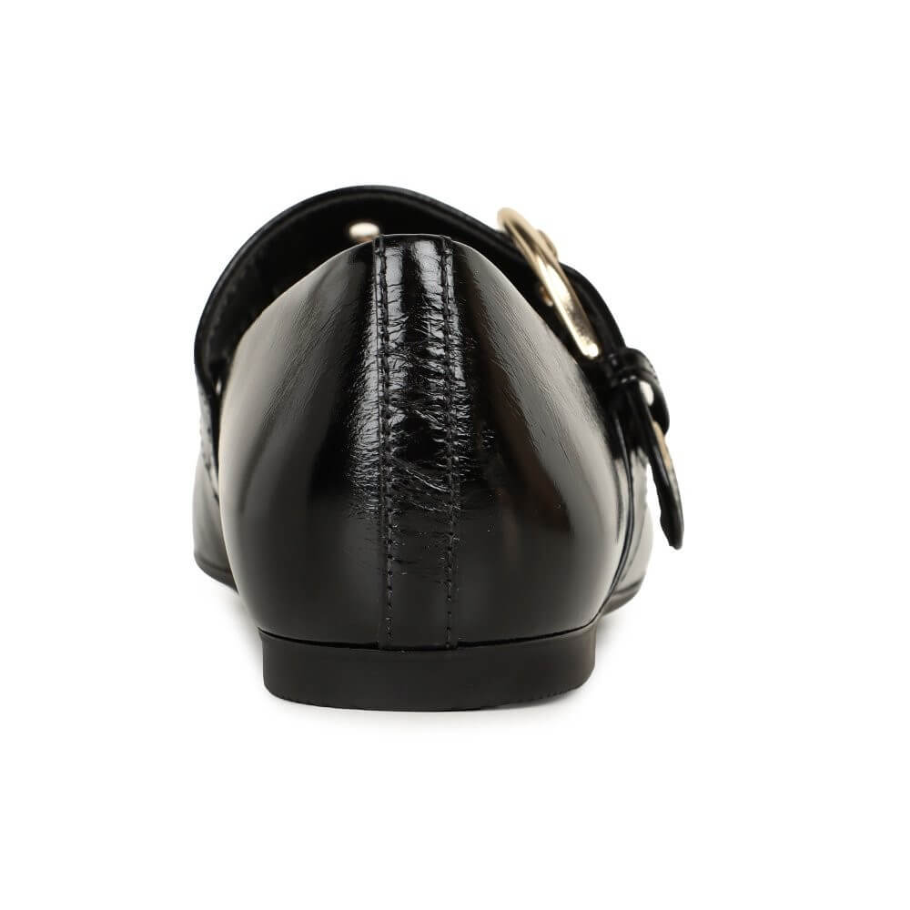 Black patent leather shoe with a buckle on a white background