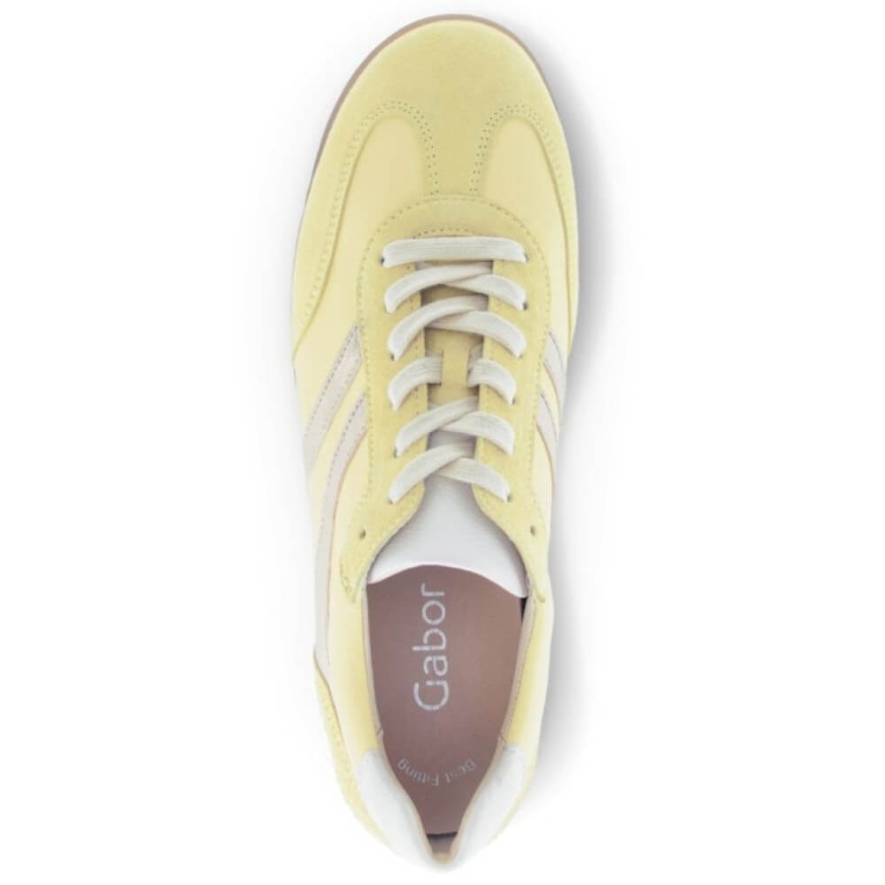Yellow sneaker with white laces on a white background