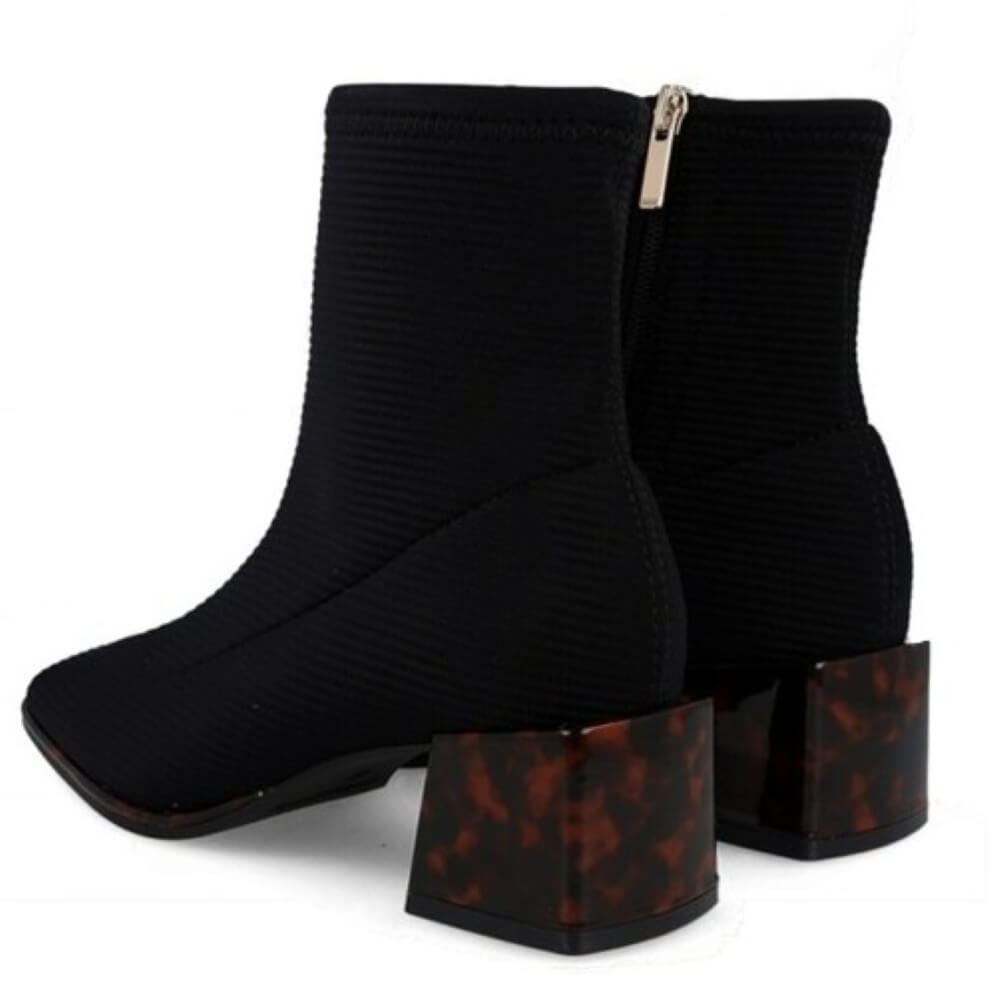 Gioseppo Black ribbed ankle boots with a block heel featuring a brown tortoiseshell pattern, shown from a three-quarter angle on a white background.