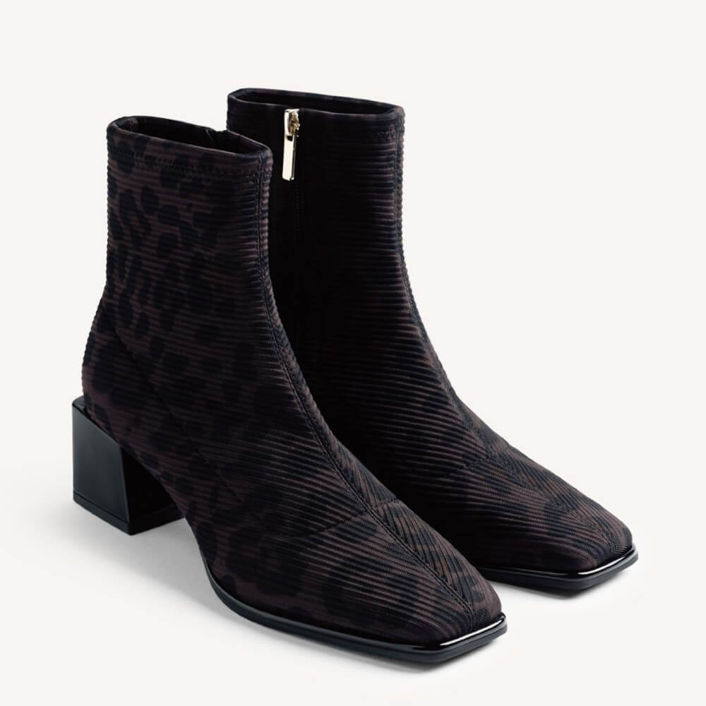 A pair of Gioseppo black ankle boots with a textured, ribbed pattern and a low block heel, shown on a light grey background.