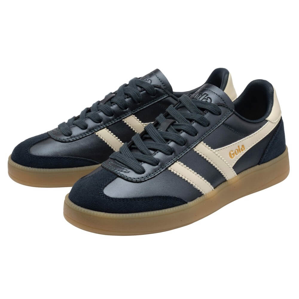 A pair of Adidas Gola sneakers in navy blue suede and leather with cream stripes, a gum sole, and gold 'Gola' branding on the side.