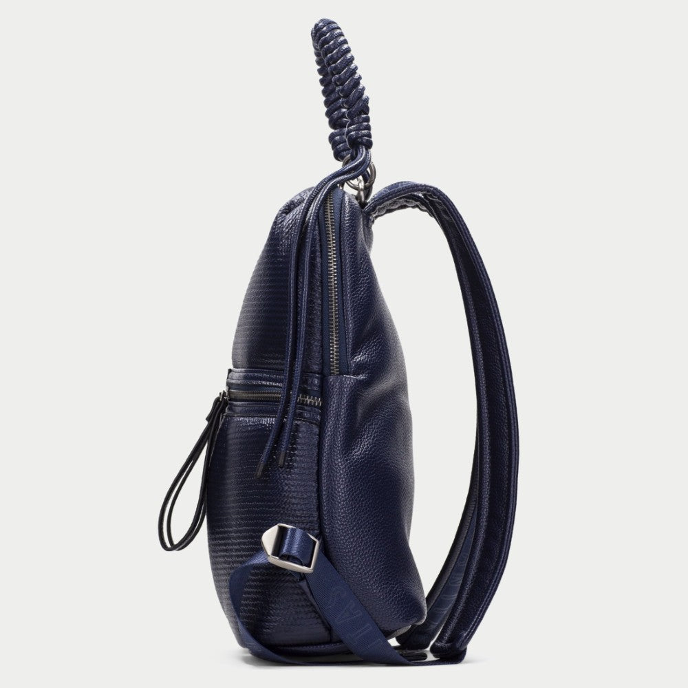 A Hispanitas navy blue textured backpack with a braided top handle, dual front zippered pockets, and a detachable shoulder strap, shown against a light grey background.