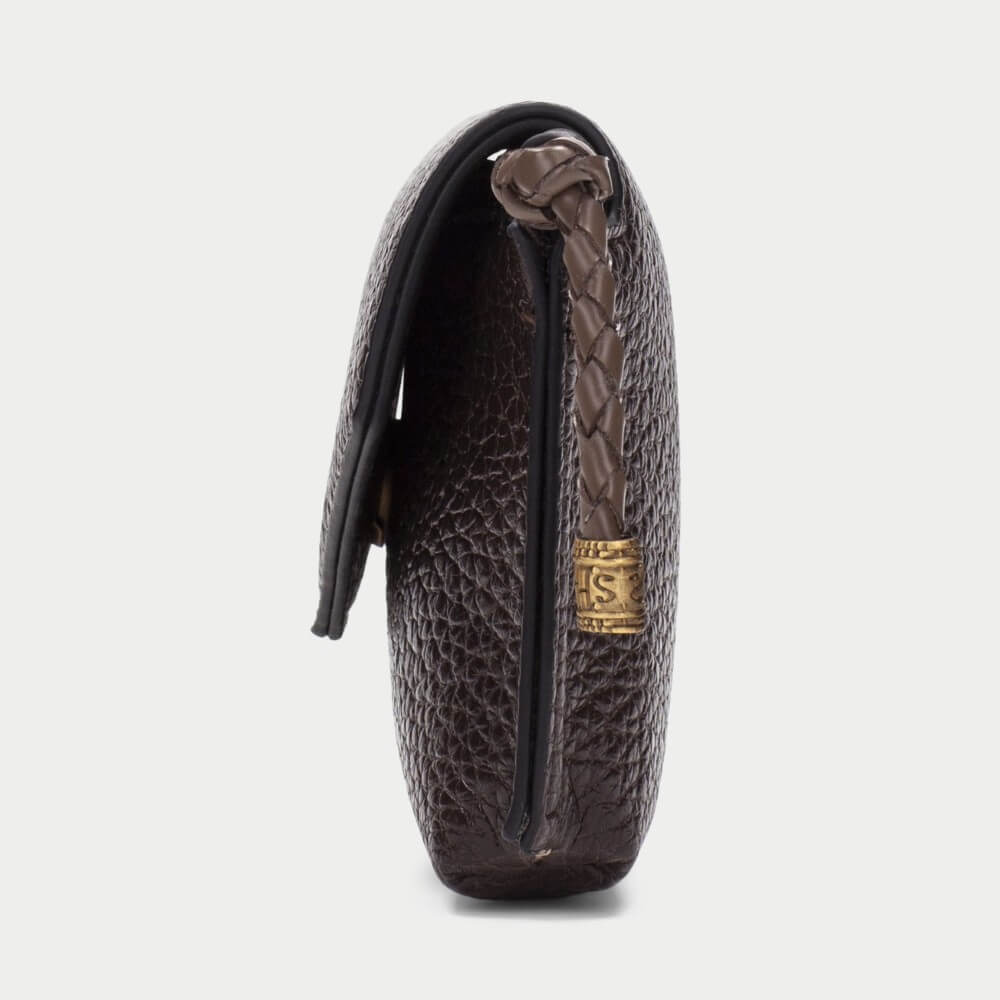 A dark brown textured leather clutch bag with a braided brown leather strap and a gold-tone metal logo plate, shown from a side profile view on a light gray background.