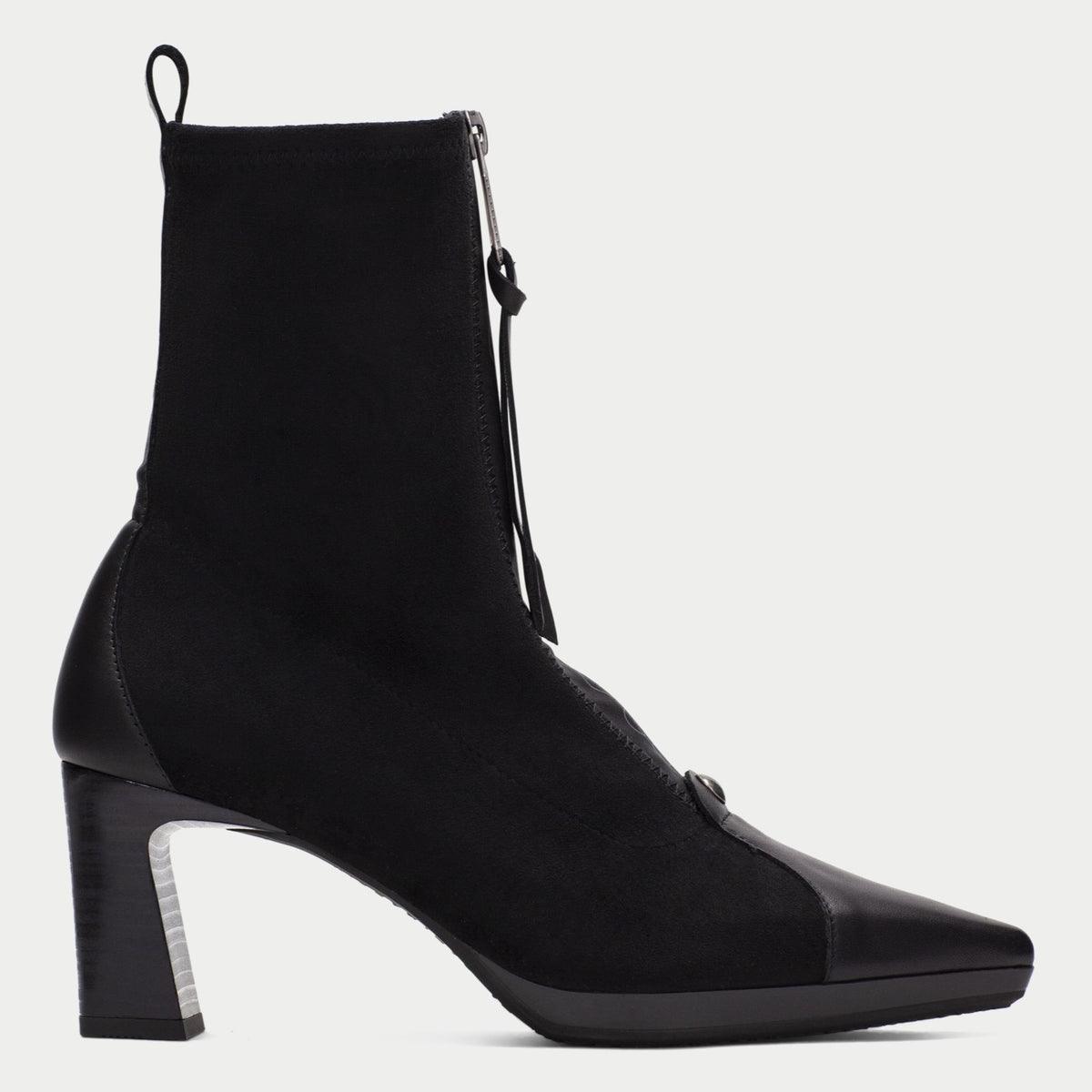 A Hispanitas black ankle boot with a pointed toe, block heel, and front zipper, shown in profile against a light grey background.
